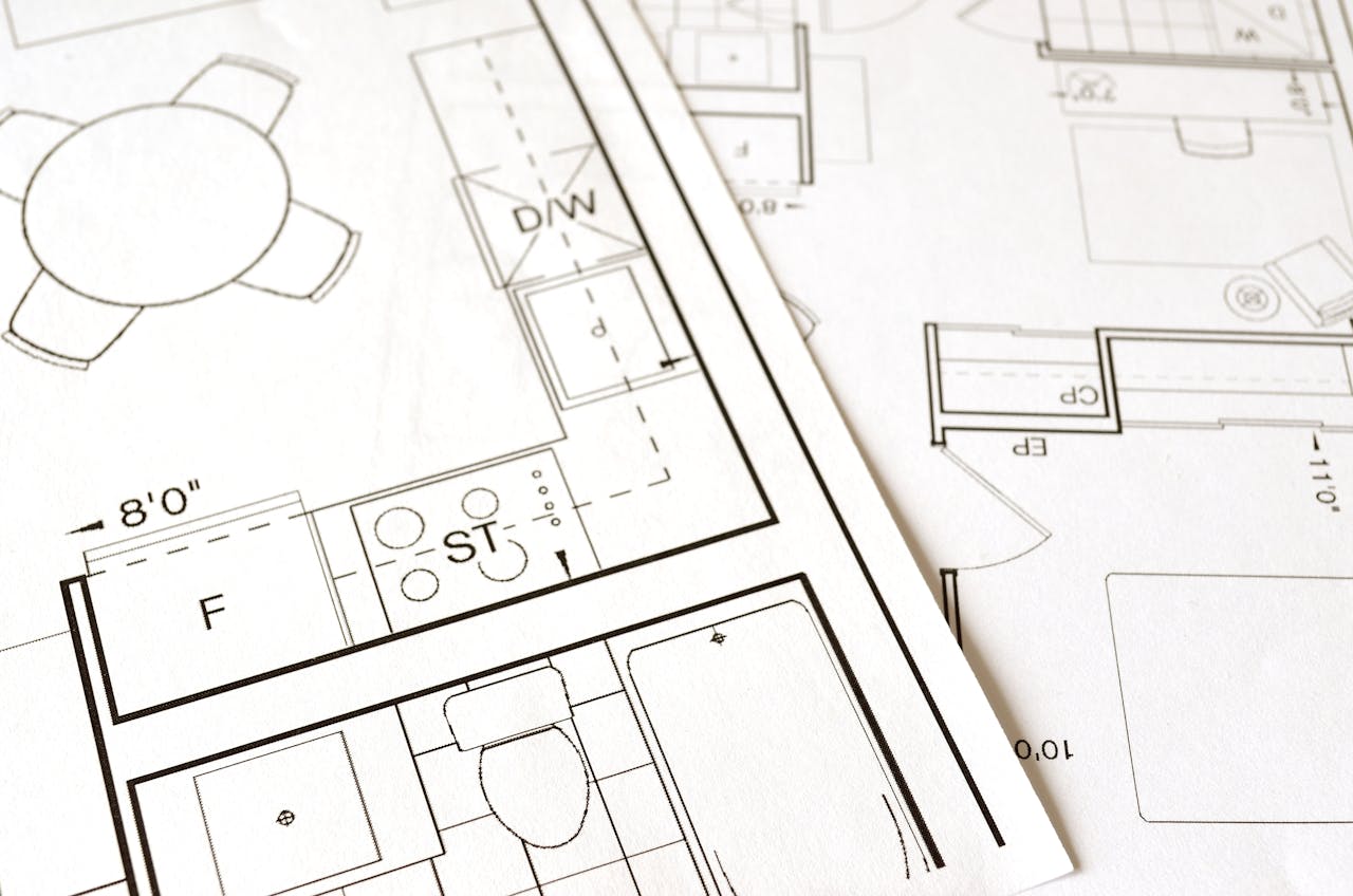 services-01 Close-up view of an architectural floor plan on paper showcasing detailed room layouts and measurements.